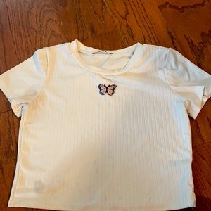 White crop top with butterfly patch.